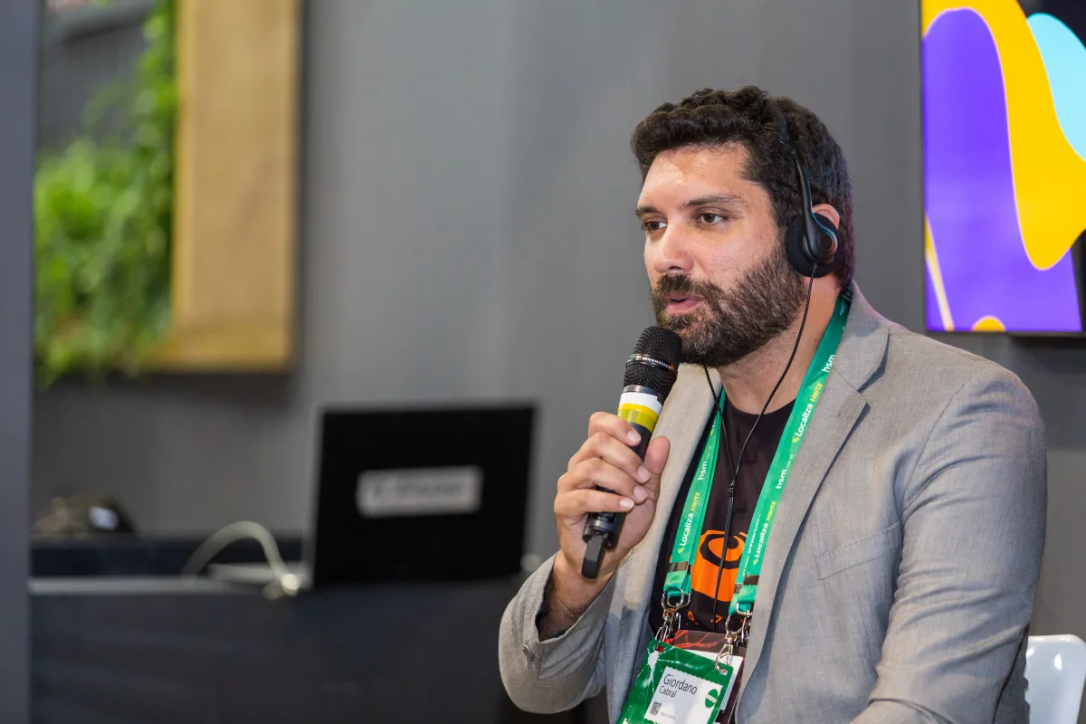Falando ao microfone, com fone de tradução, no painel 